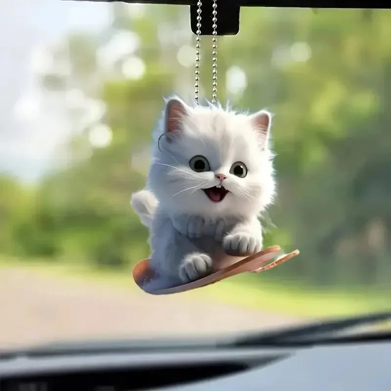 Cute cat-shaped rearview mirror ornament hanging from a car interior, decorative pendant for auto interior decor.