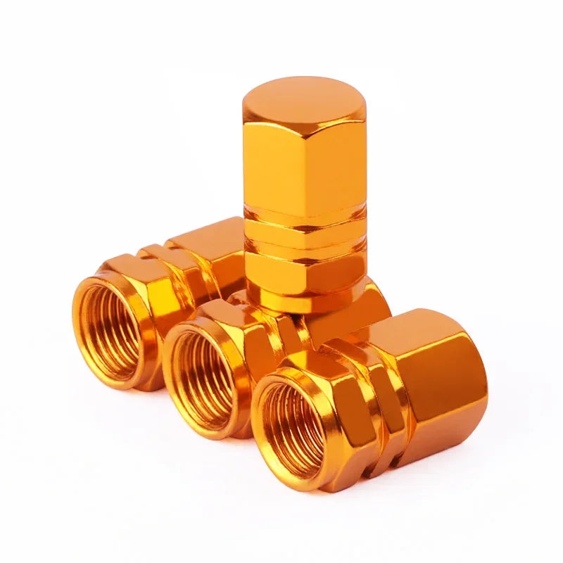 Red aluminum alloy tire valve stem caps for car, motorcycle, and bicycle, dustproof and durable, shown on vehicle wheel.