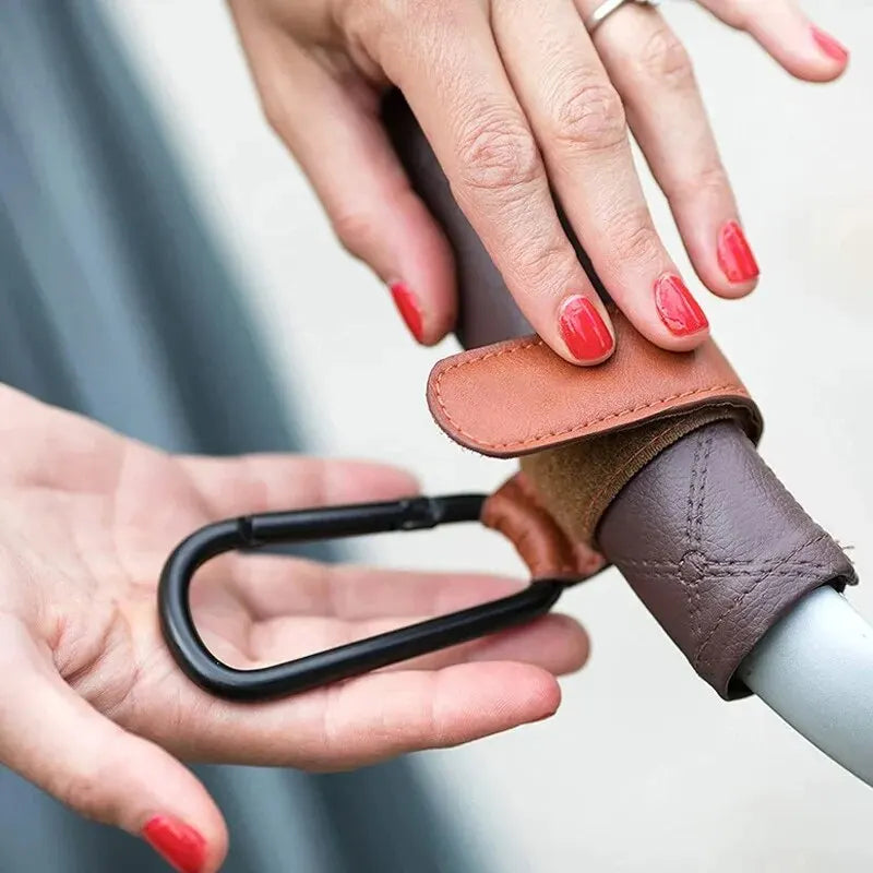 Set of two pink PU leather stroller hooks from FanzyMarket, adjustable and universal for diaper bags and nursery organization.