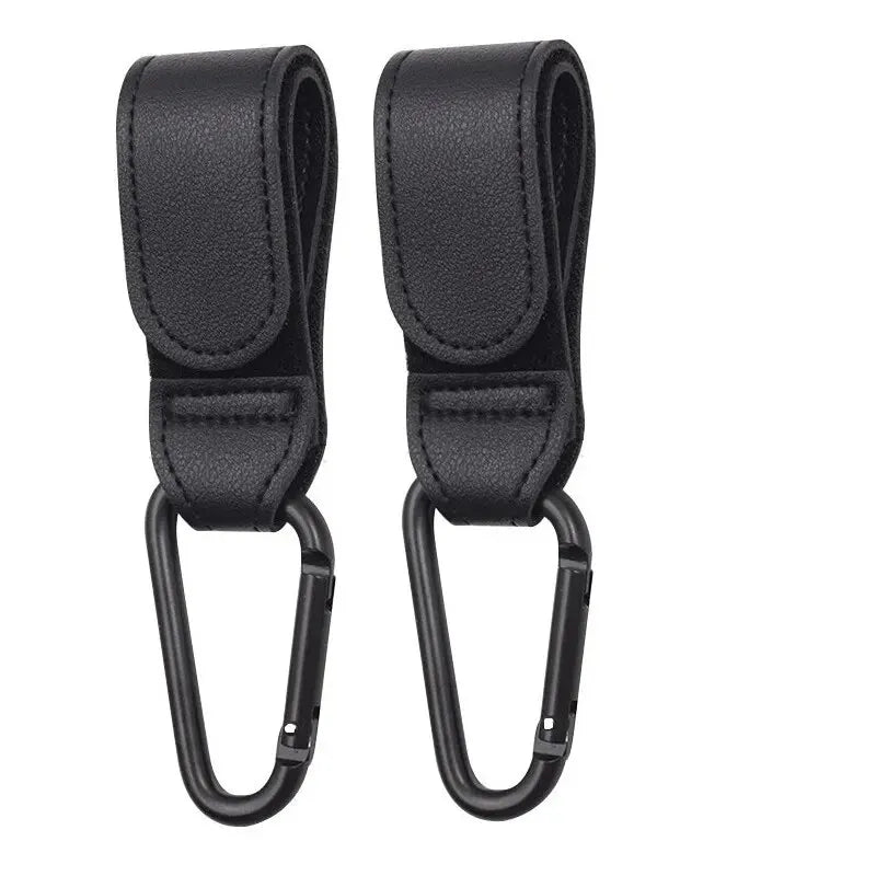 Two pink PU leather stroller hooks from FanzyMarket, adjustable pram bag hangers for diaper bags and baby care accessories.