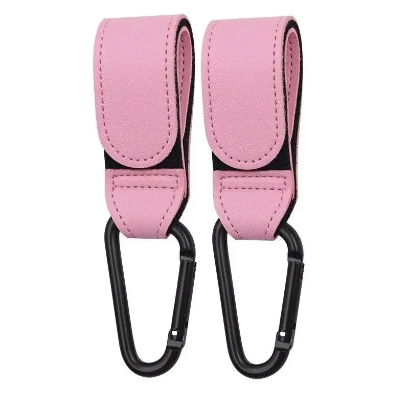 Two pink PU leather stroller hooks by FanzyMarket, adjustable and universal for baby diaper bags and nursery organization.