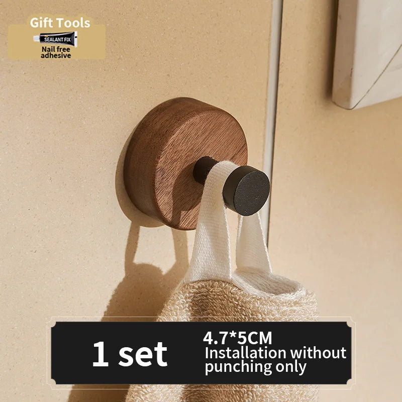 Black aluminum wall-mounted robe hook by FanzyMarket with adhesive, suitable for towels, coats, and bags, available in 1-3 hooks.