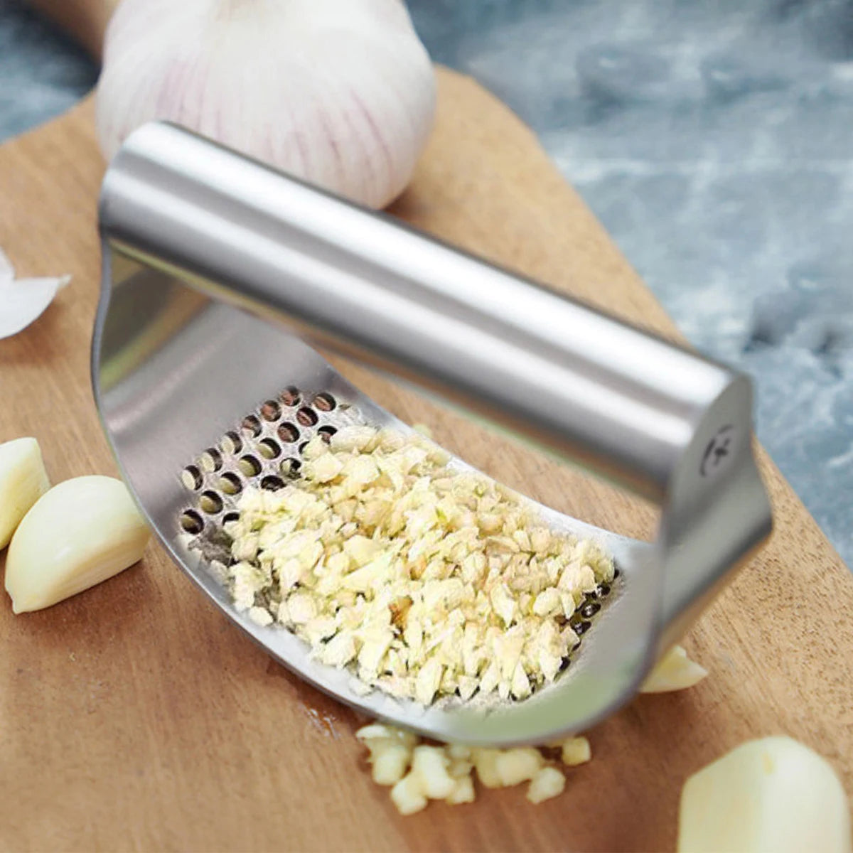 FanzyMarket stainless steel garlic press and ginger crusher, manual kitchen tool for mincing garlic and ginger easily.