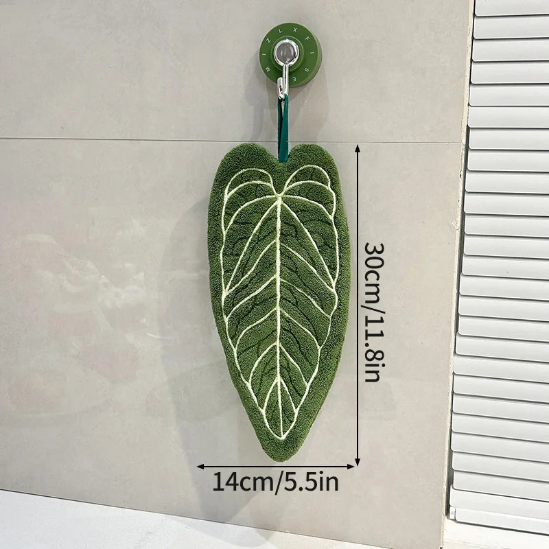 FanzyMarket leaf-shaped coral fleece hand towel hanging in kitchen or bathroom, absorbent and decorative for drying hands.