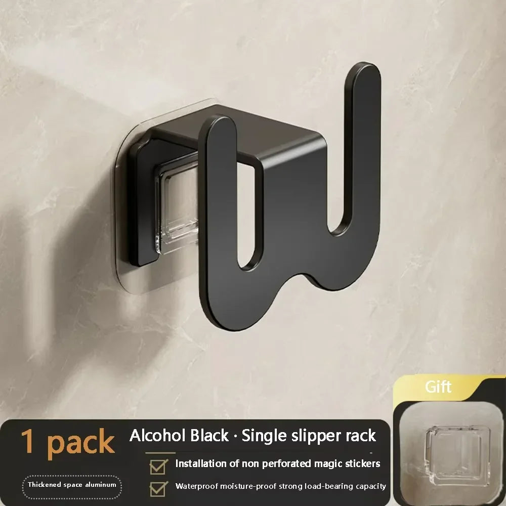 Black wall-mounted bathroom slipper rack with rear drainage and single-tier shoe storage hook for organized home and bathroom use.