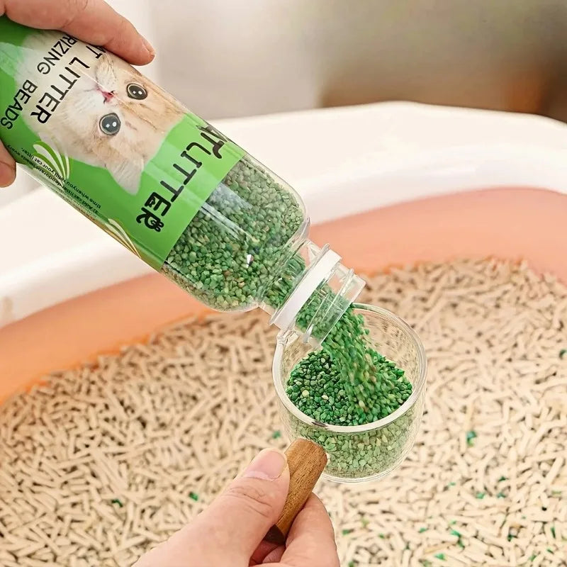 FanzyMarket cat litter deodorizer beads in a green bottle, odor eliminator and litter box freshener for pet hygiene.