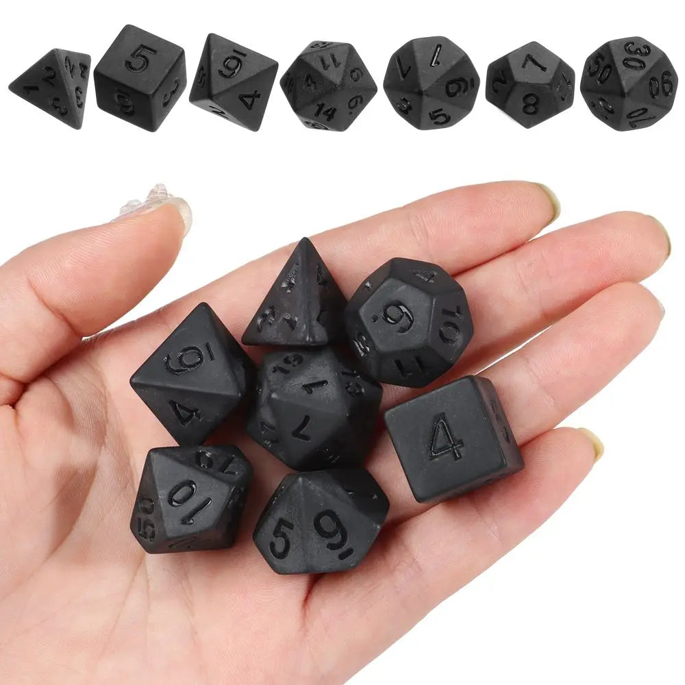 Black polyhedral dice set for D&D and tabletop RPGs, 7-piece FanzyMarket dice set with various shapes and numbers for gaming.