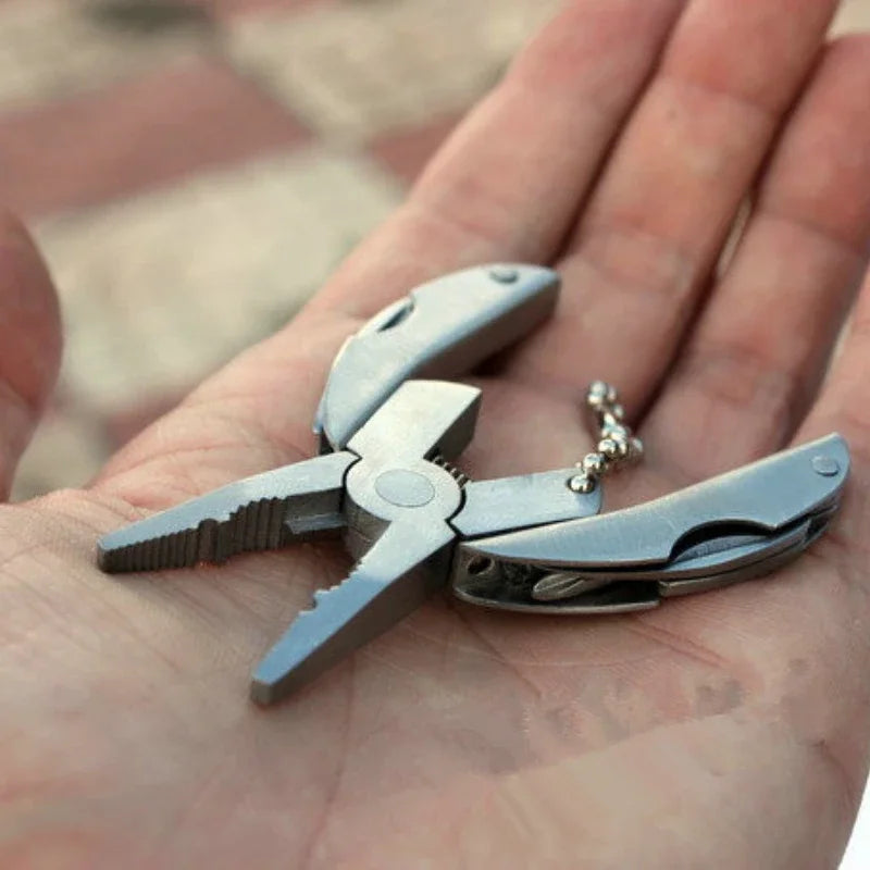 FanzyMarket compact steel multi-tool folding pliers with knife, screwdriver, and keychain for camping and outdoor survival activities.