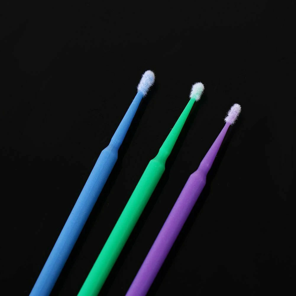 Three disposable micro paint brushes in blue, green, and purple