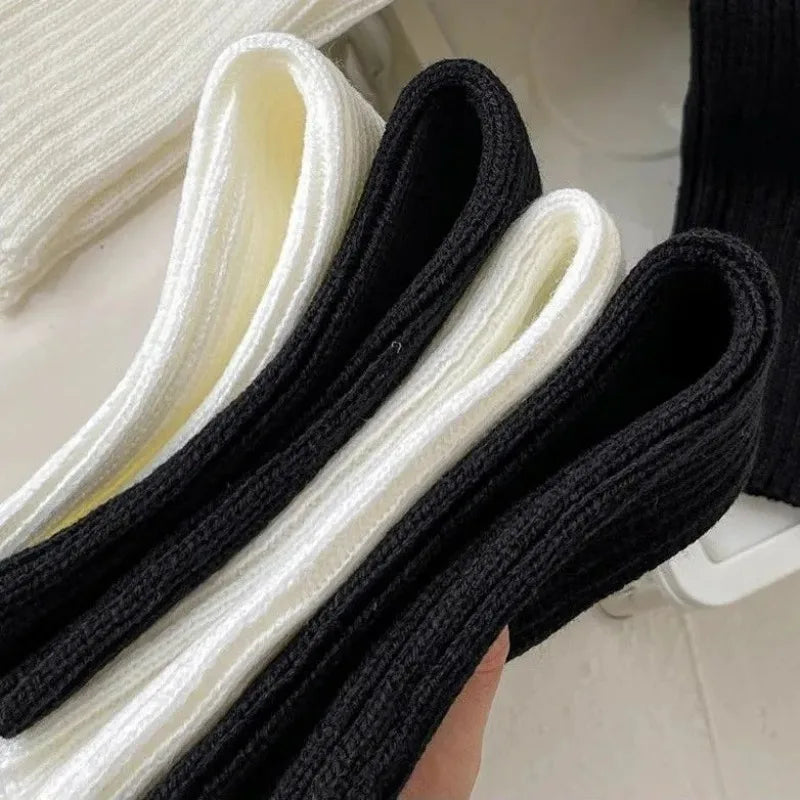 Pair of black and white Y2K knit leg warmers with crochet design, 50cm length, worn on legs, fashion accessories for women.