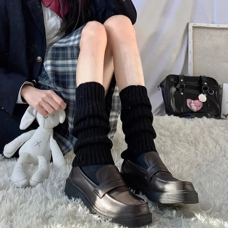 Pair of black and white Y2K knit leg warmers with crochet design, 50cm length, styled as boot cuffs for women.