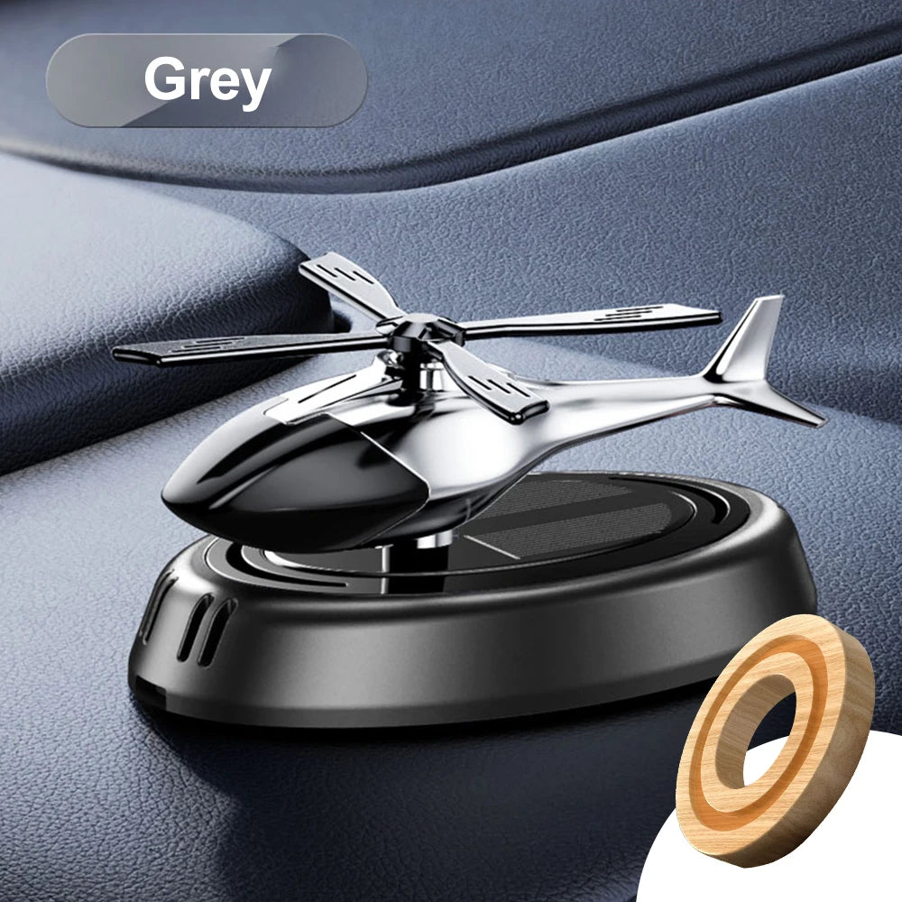 Red solar helicopter propeller car air freshener and aromatherapy diffuser, decorative accessory for vehicle interior.