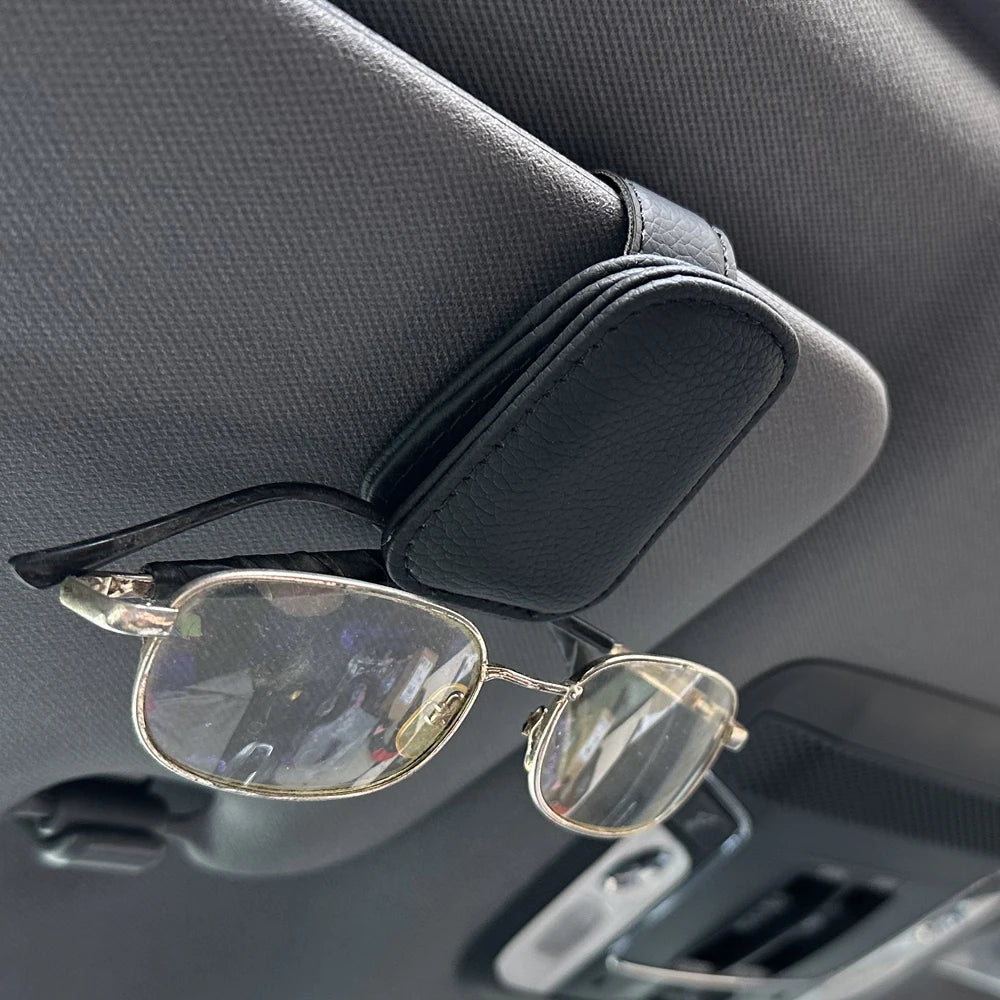 FanzyMarket magnetic car sunglasses holder with foldable leather design, fits sun visors, holds glasses and cards securely inside vehicle.