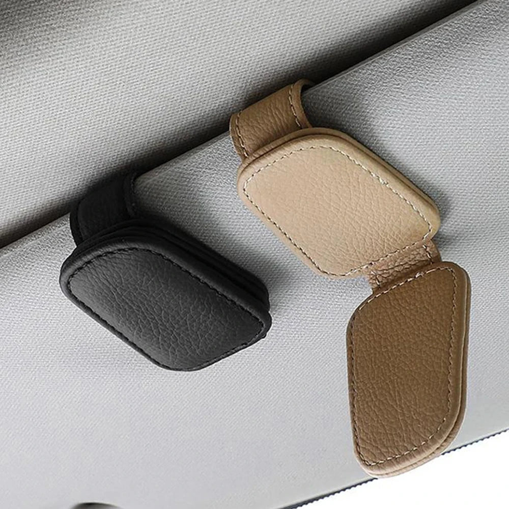 Beige FanzyMarket magnetic car sunglasses holder with foldable leather sun visor clip for glasses and cards inside a vehicle.