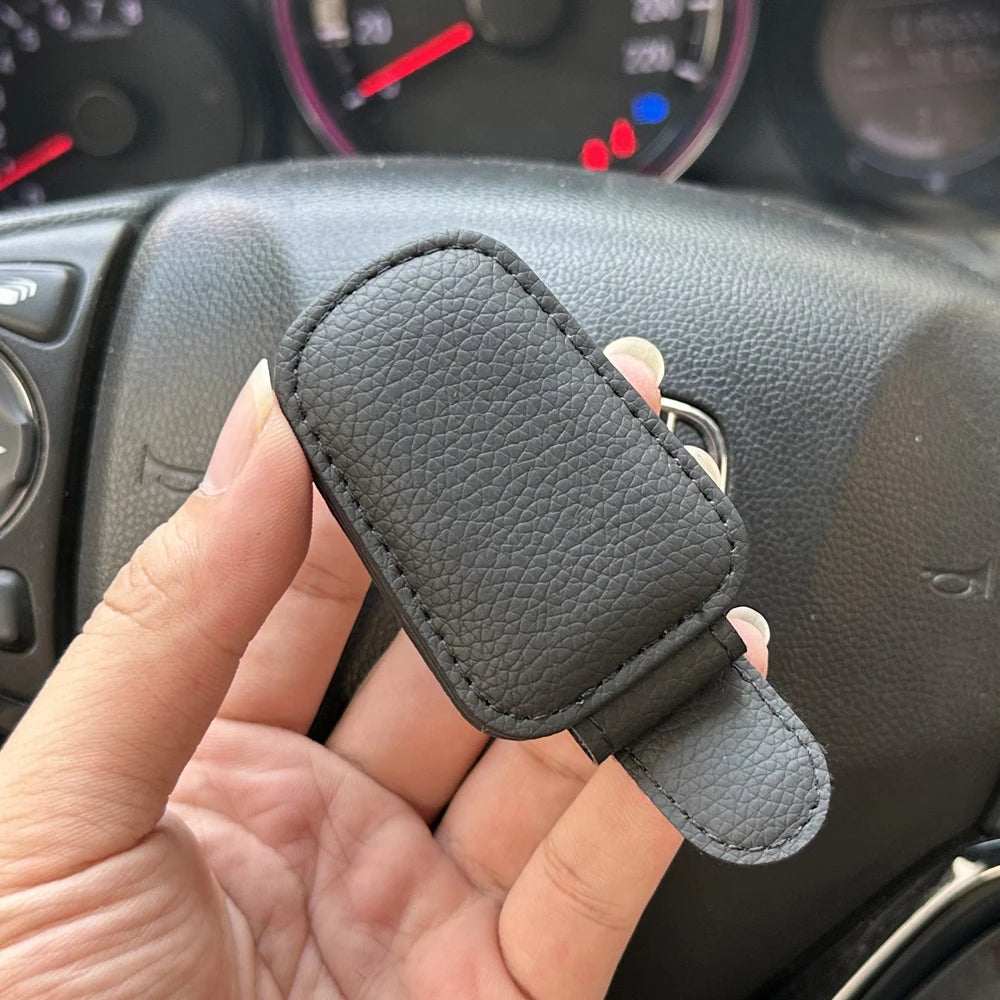 FanzyMarket magnetic car sunglasses holder on beige sun visor, foldable leather design with space for glasses and cards.