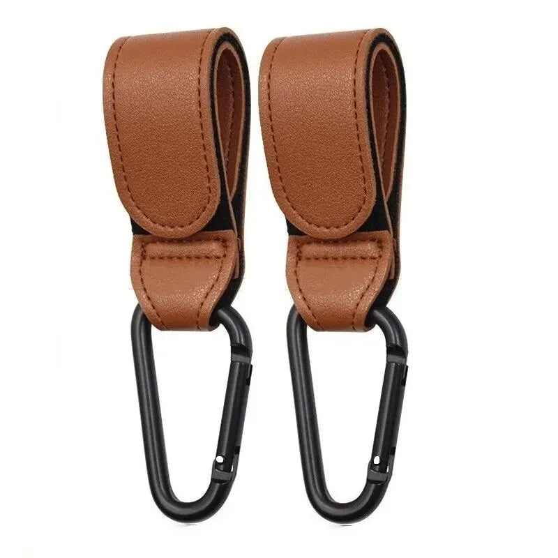 Two pink PU leather stroller hooks from FanzyMarket, adjustable pram bag hangers for universal diaper bag organization.