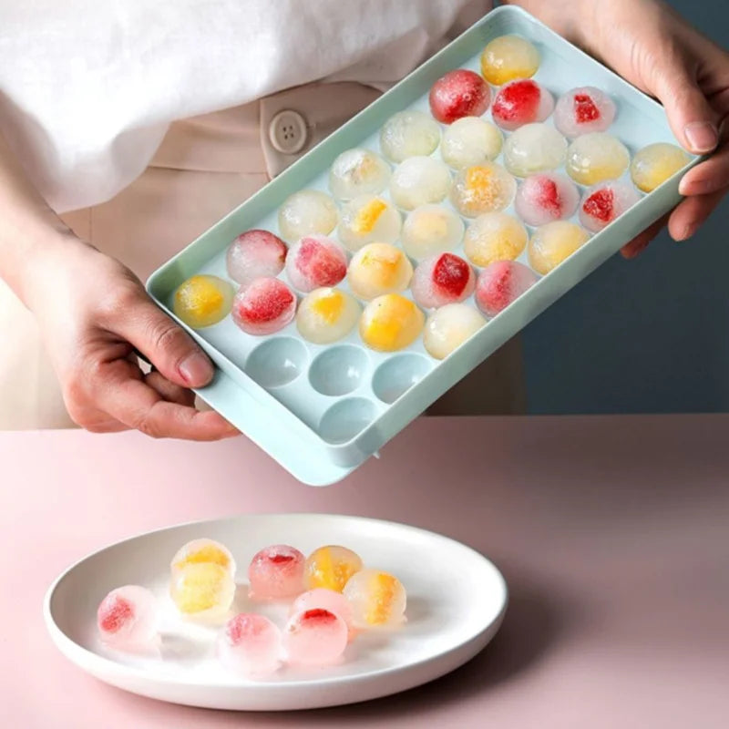 FanzyMarket 33-cavity round ice ball tray in blue, made of plastic, for whiskey, cocktails, popsicles, and lollipops.