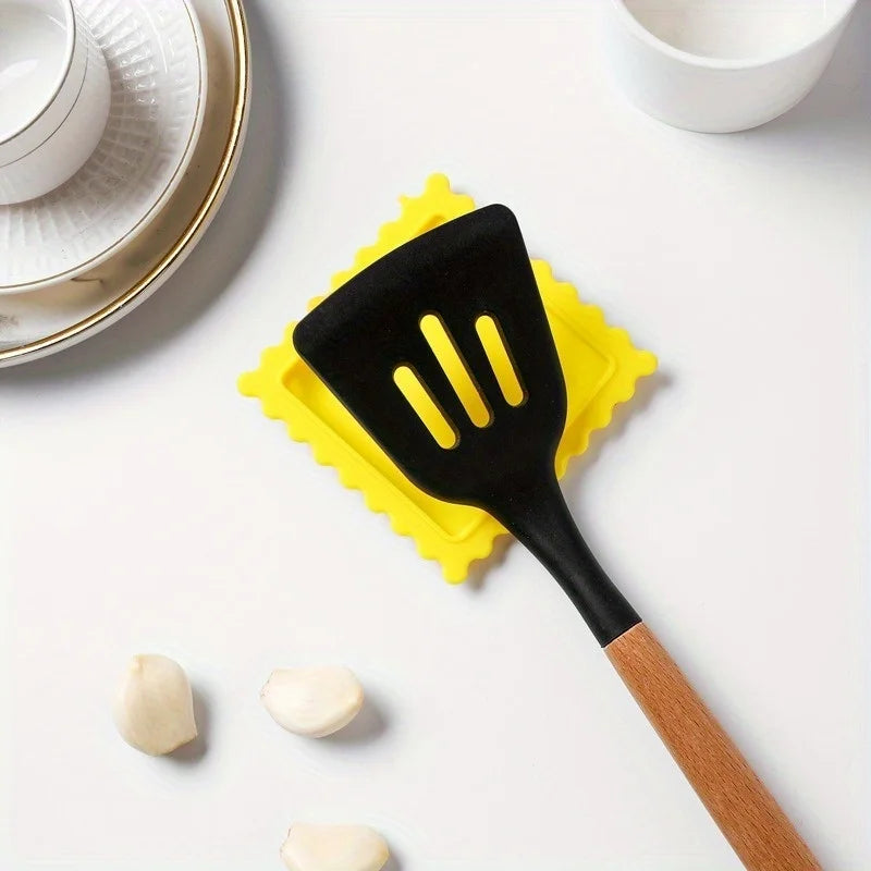 Cartoon biscuit-shaped silicone spoon rest by FanzyMarket, heat-resistant, anti-scald, non-slip kitchen spoon holder for cookware.