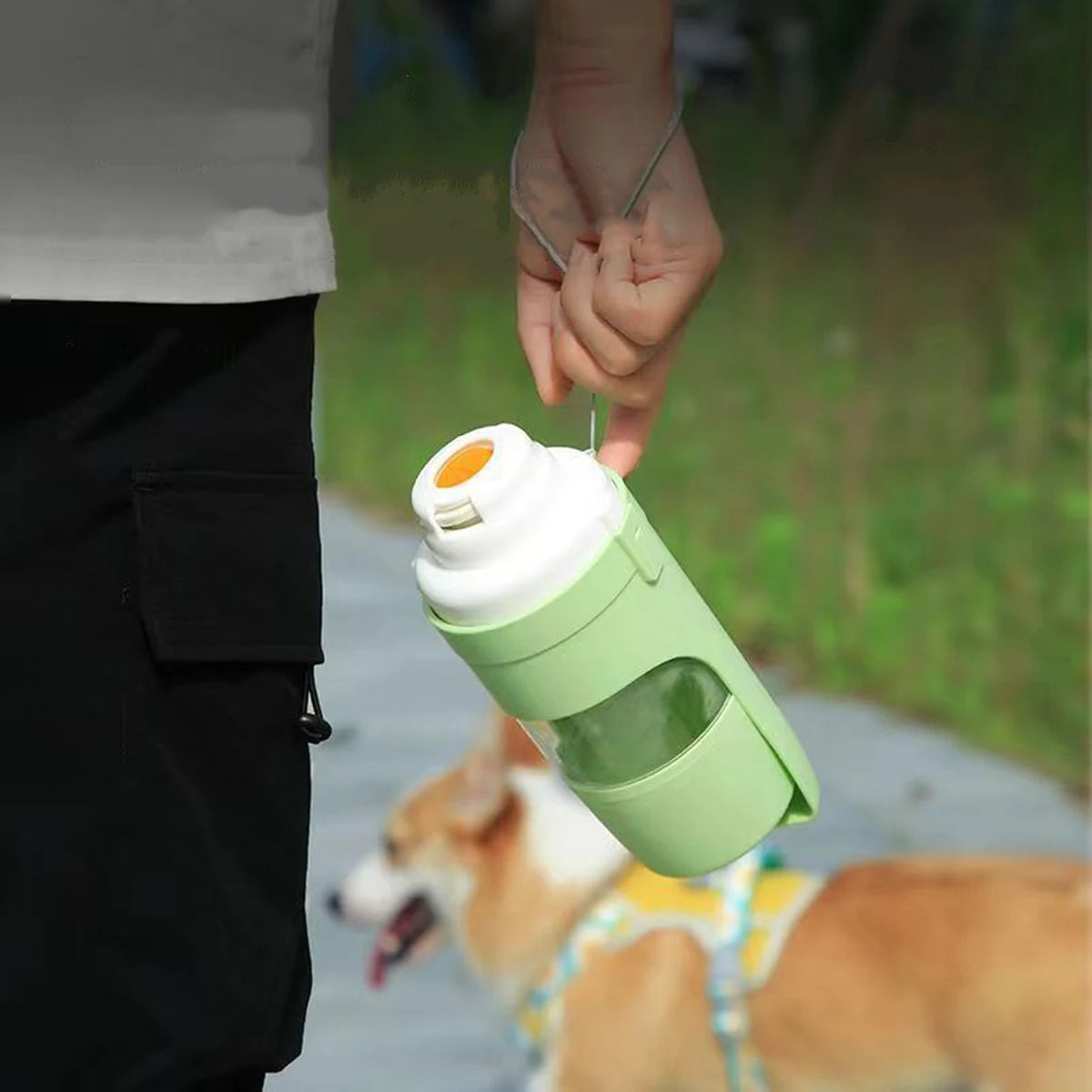 Pink portable pet water bottle with food storage and foldable bowl, ideal for dogs and cats during travel.