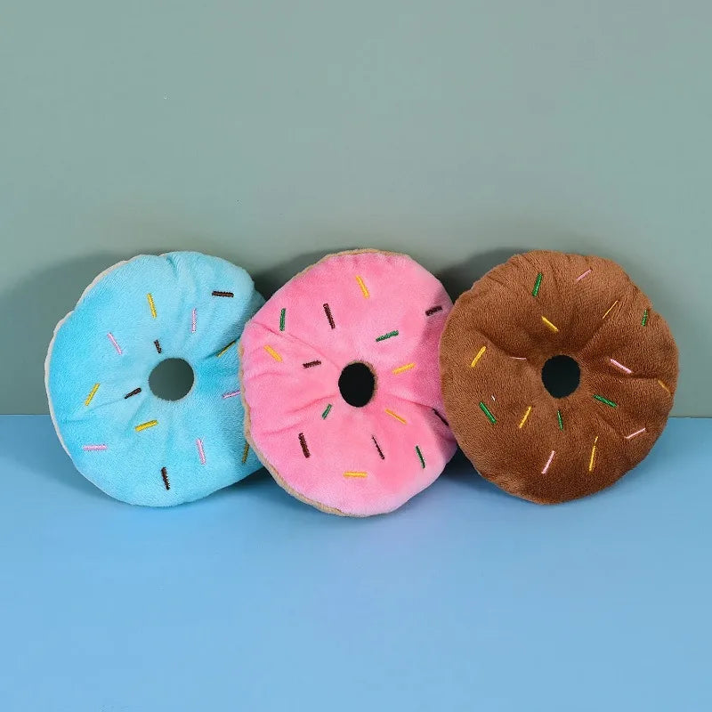 Pink plush donut chew toy with squeaker for small and medium dogs, soft fleece material, 4.3 inches in size.